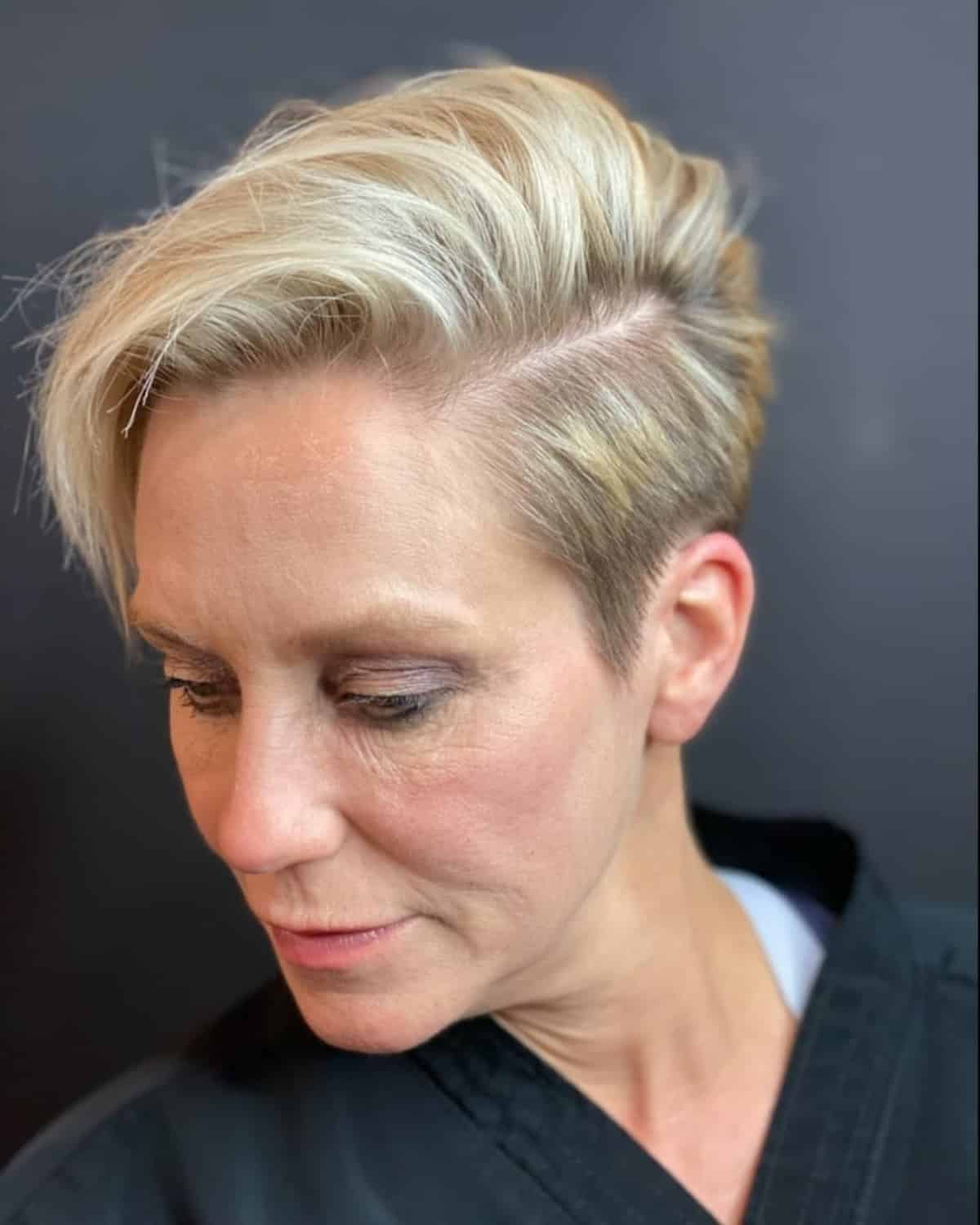 Homme de 60 ans avec une coupe asymétrique et un côté rasé.