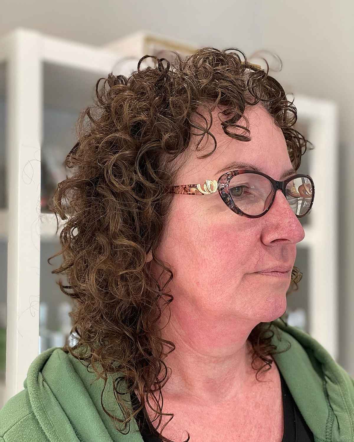 Cheveux frisés pour les femmes de plus de 60 ans avec des lunettes.