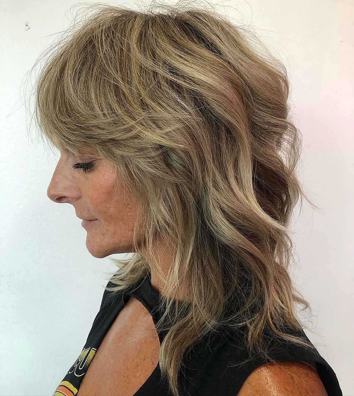 Coupe au rasoir pour une femme de 60 ans aux cheveux mi-longs