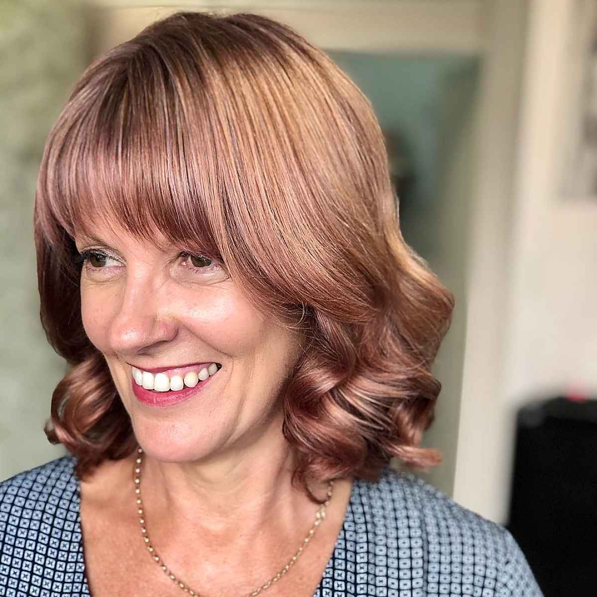 Cheveux ondulés avec franges pour les femmes de plus de 40 ans