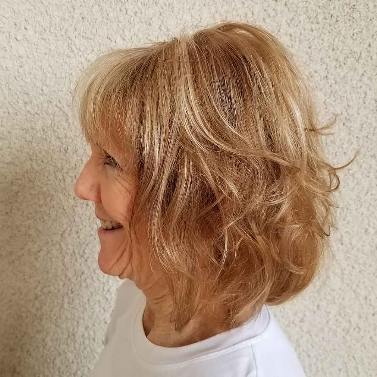 Cheveux courts ondulés avec frange pour les femmes plus âgées