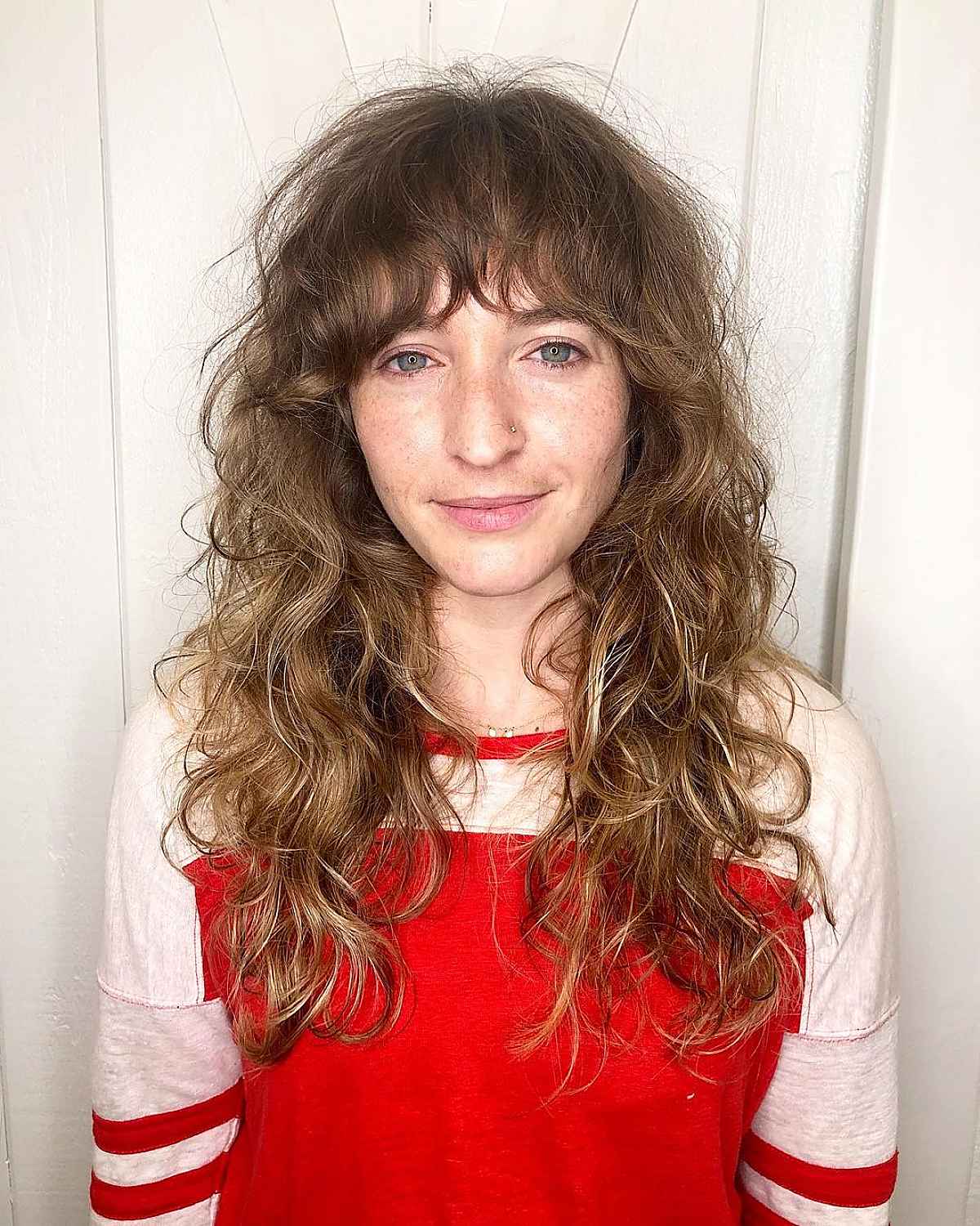 Coiffure ondulée avec frange en plumes