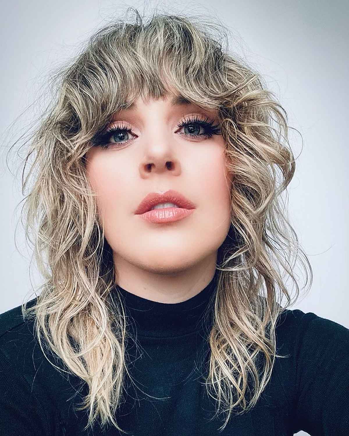 Cheveux mi-longs ondulés avec frange