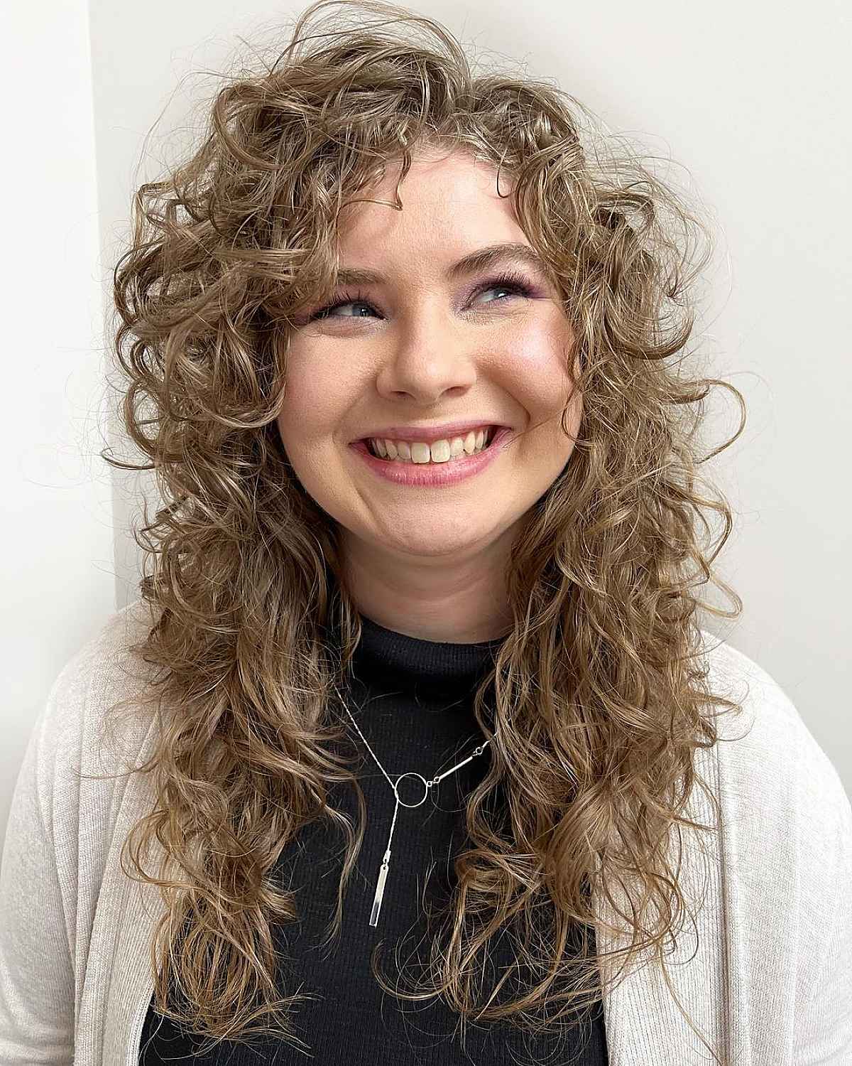 Boucles coiffées sur le côté et texture ébouriffée