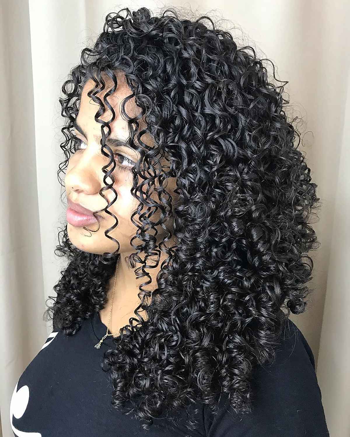 Coiffure noire longue et bouclée