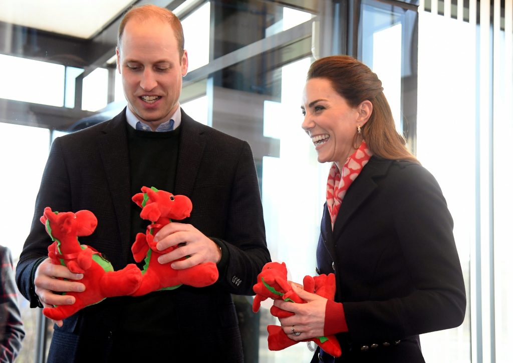 Le prince William, duc de Cambridge, et Catherine, duchesse de Cambridge, réagissent en tenant des jouets en forme de dragon qu'ils ont reçus pour leurs enfants.