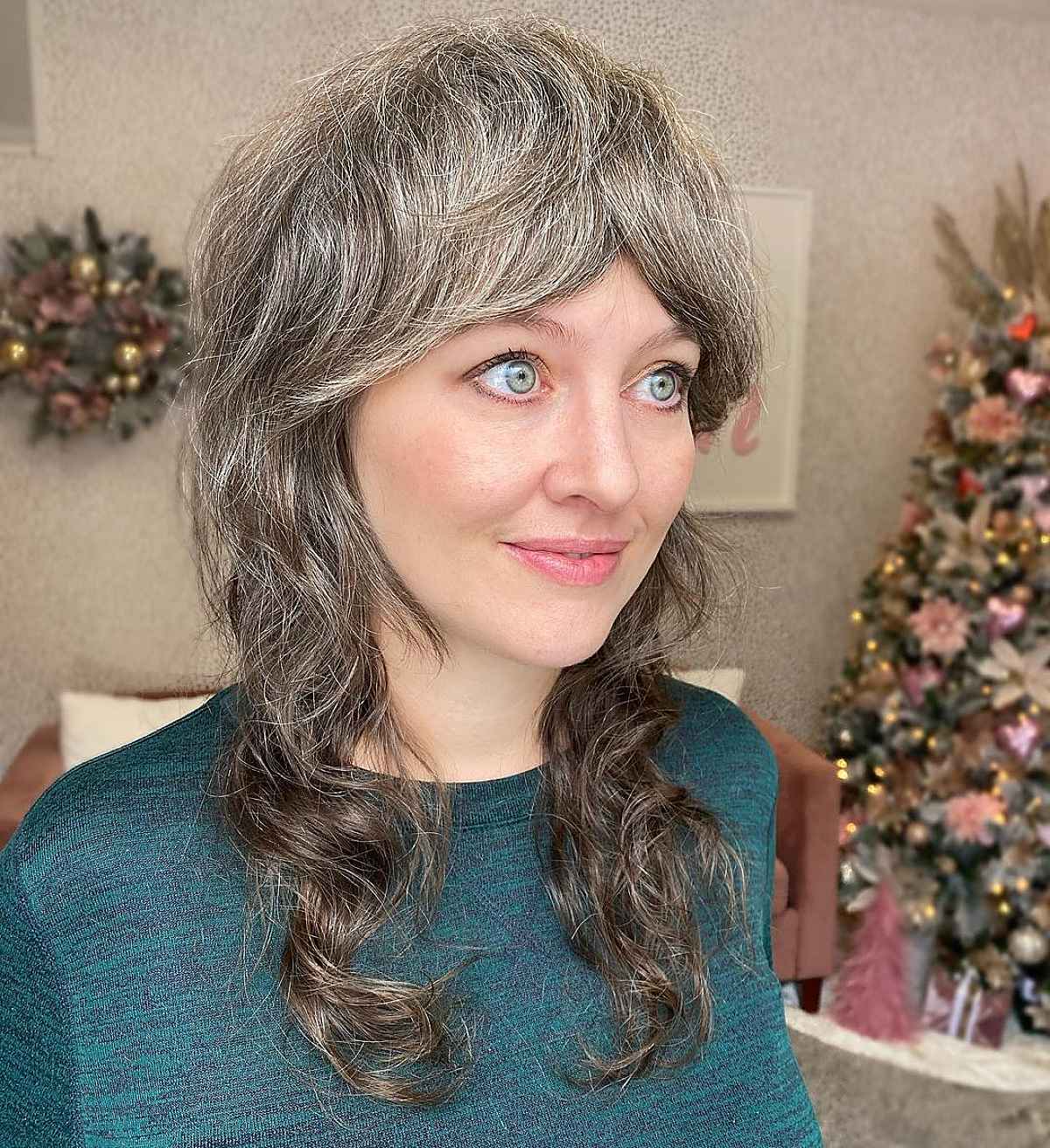 Coiffure dégradée avec frange et boucles lâches.
