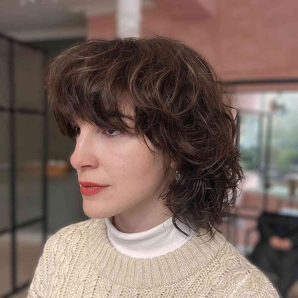 Cheveux courts dégradés avec frange pour visages ovales et cheveux épais ondulés