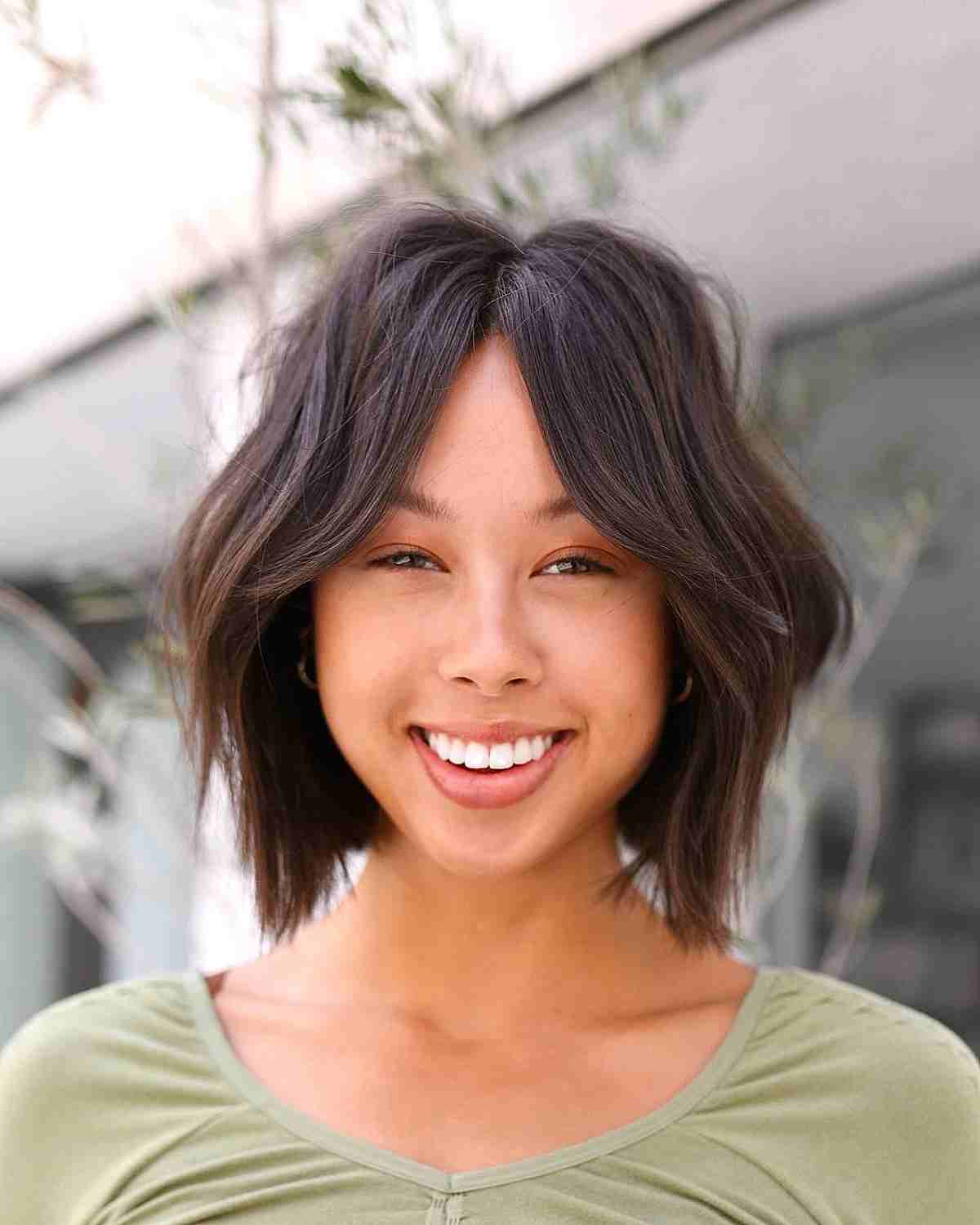 Coiffure ondulée avec franges en rideau.