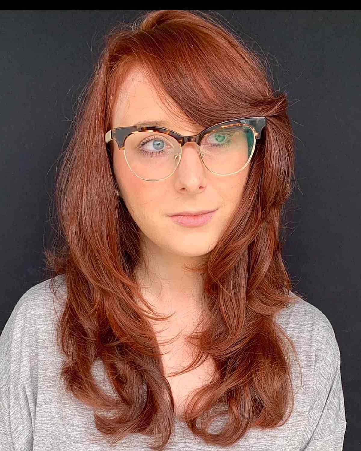 Cheveux dégradés au milieu du dos avec une frange balayée sur le côté et une raie profonde sur le côté.