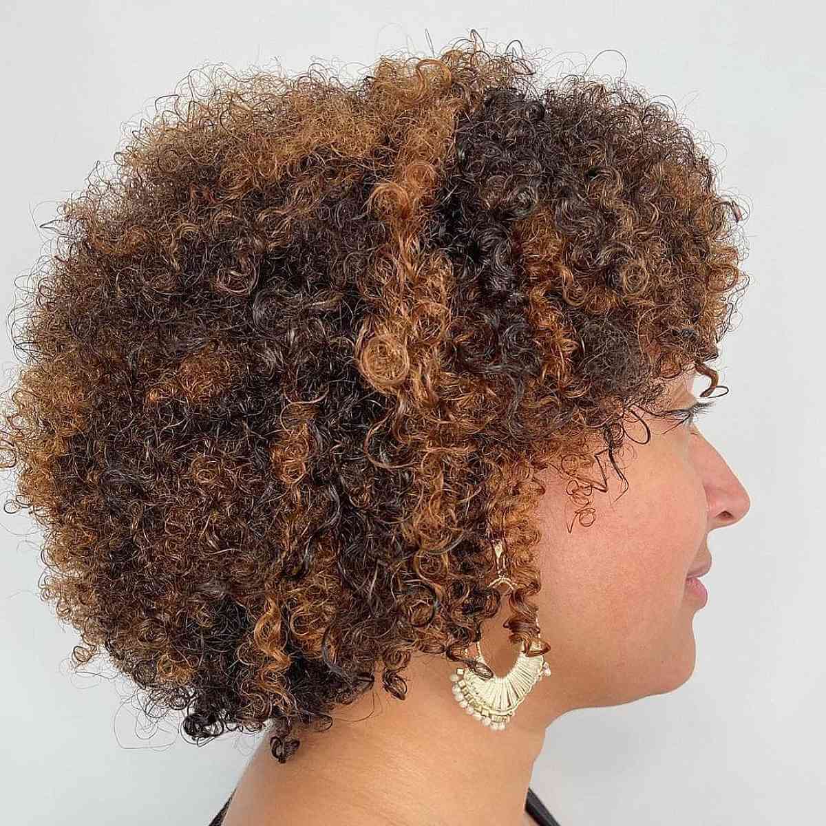 Cheveux courts bouclés avec des mèches auburn balayées