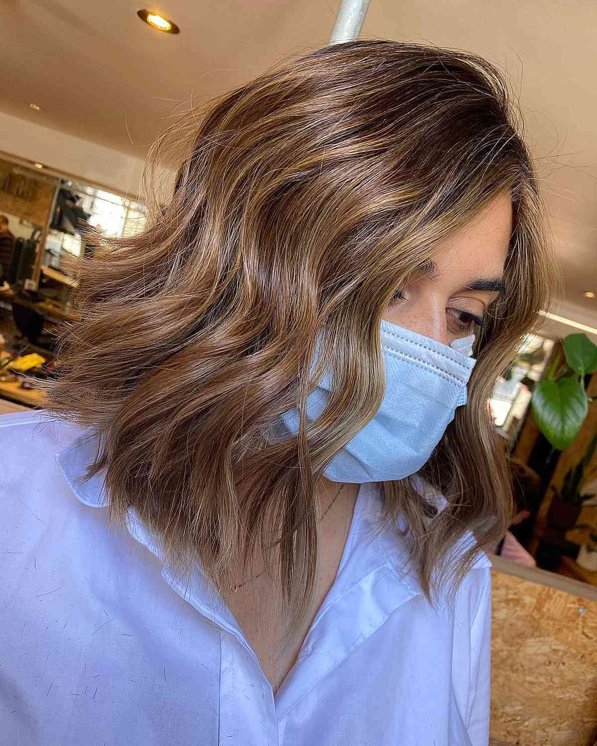 Lobe brun clair coupé avec des mèches caramel