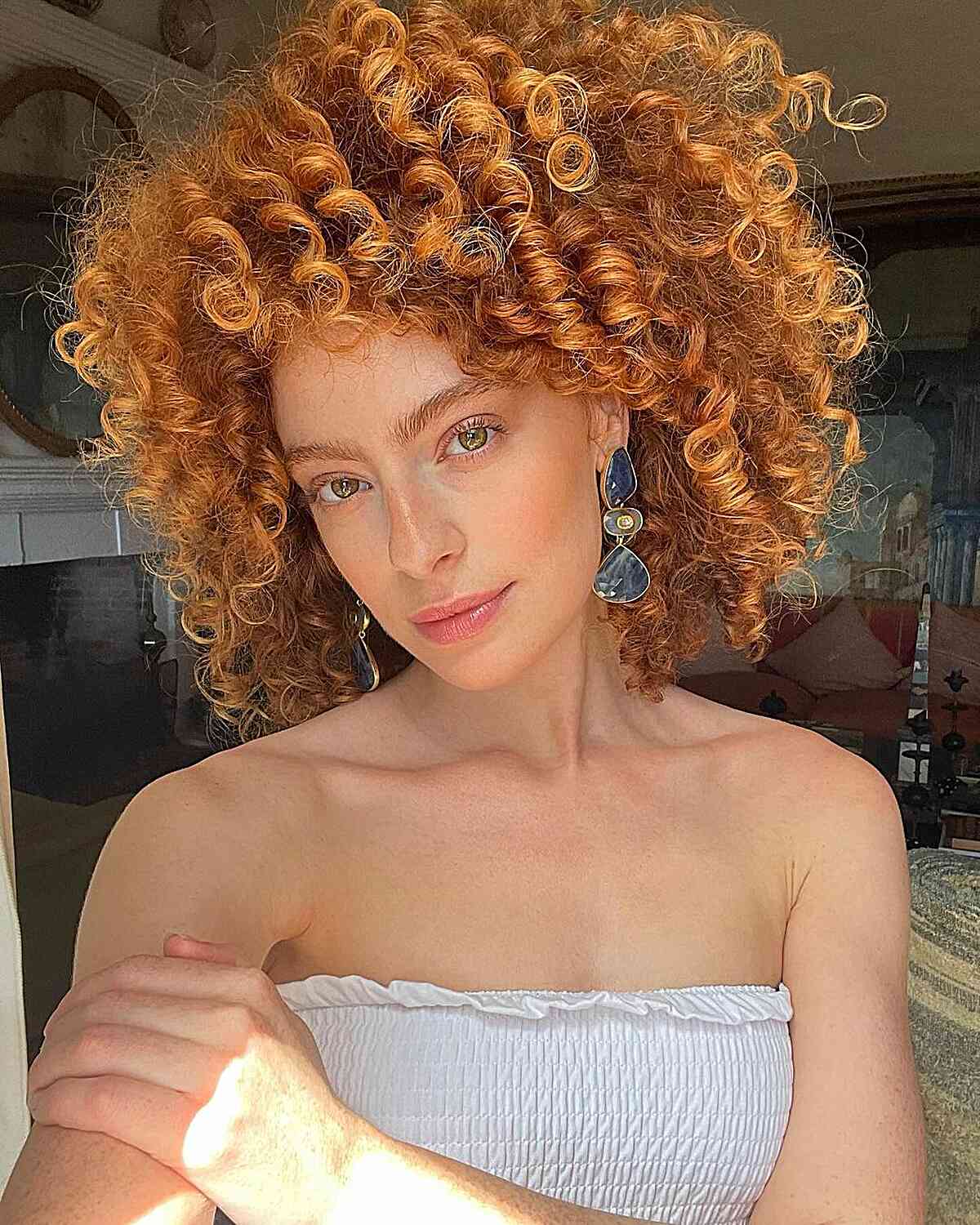   Une femme avec une coupe Cadō de la longueur de la nuque mettant en valeur des boucles rebondissantes et une superposition stratégique pour un style enjoué et volumineux.