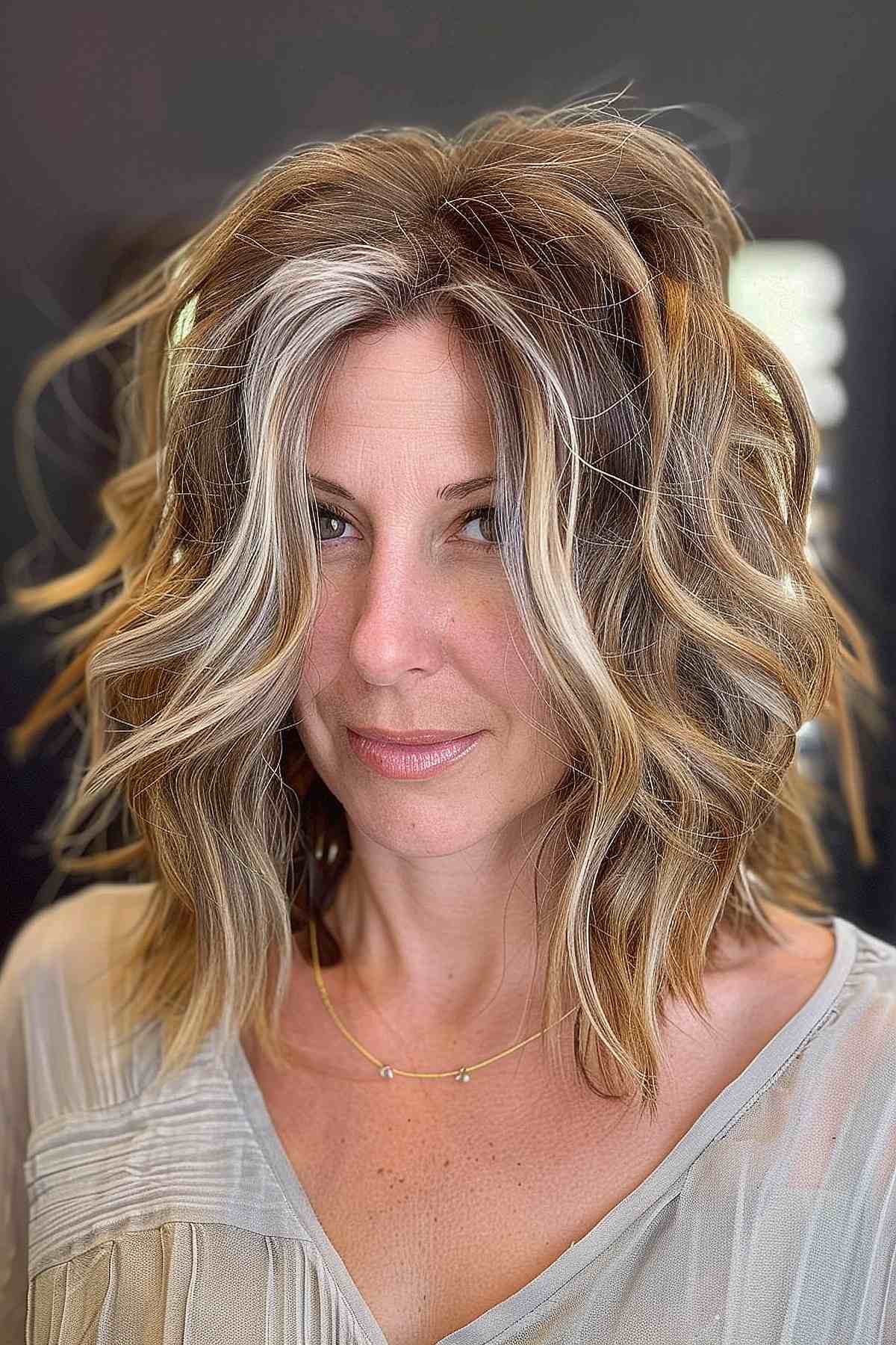 Coupe shag décoiffée avec des mèches blondes à l'avant et des dégradés