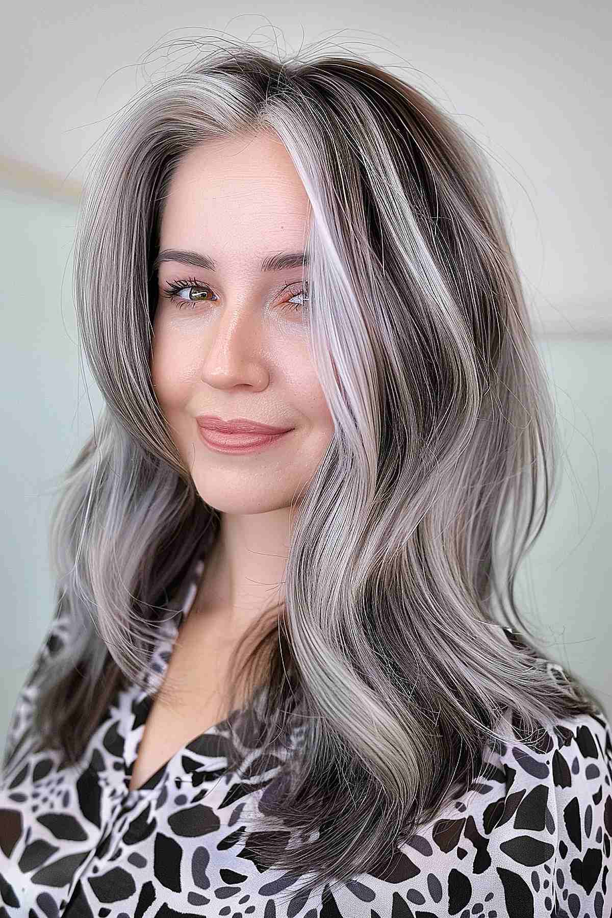 Cheveux mi-longs avec mèches chunky gris-blond et ondulations douces