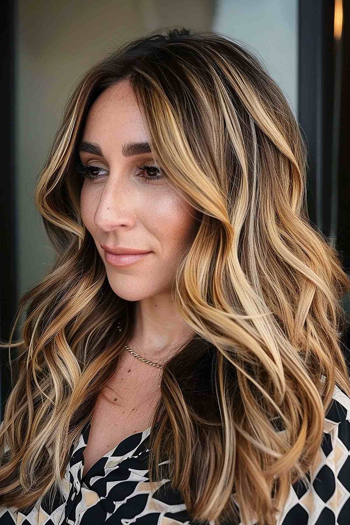Cheveux longs et ondulés avec des mèches blond sale et des racines foncées