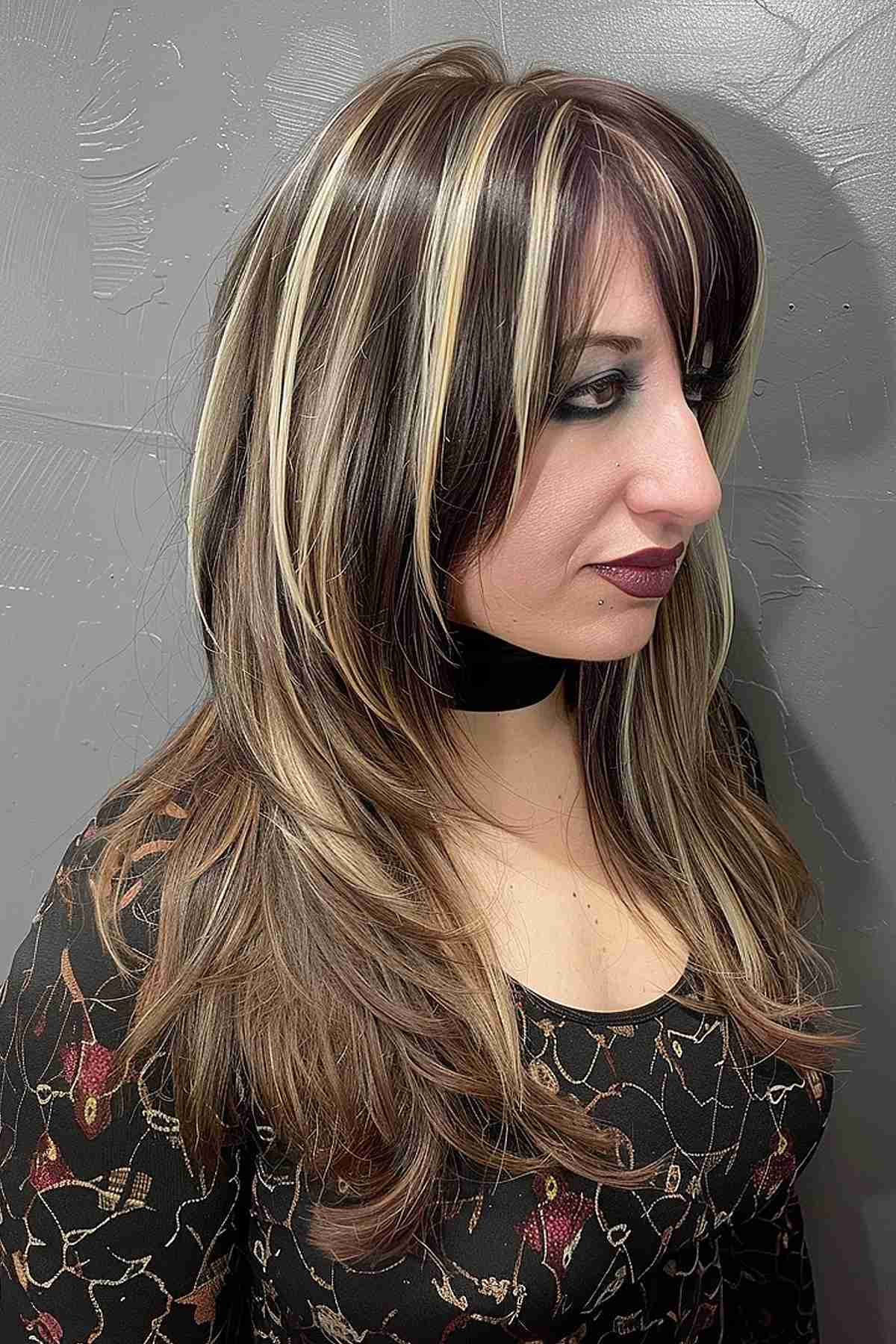 Cheveux noirs mi-longs avec des mèches blondes et des dégradés doux