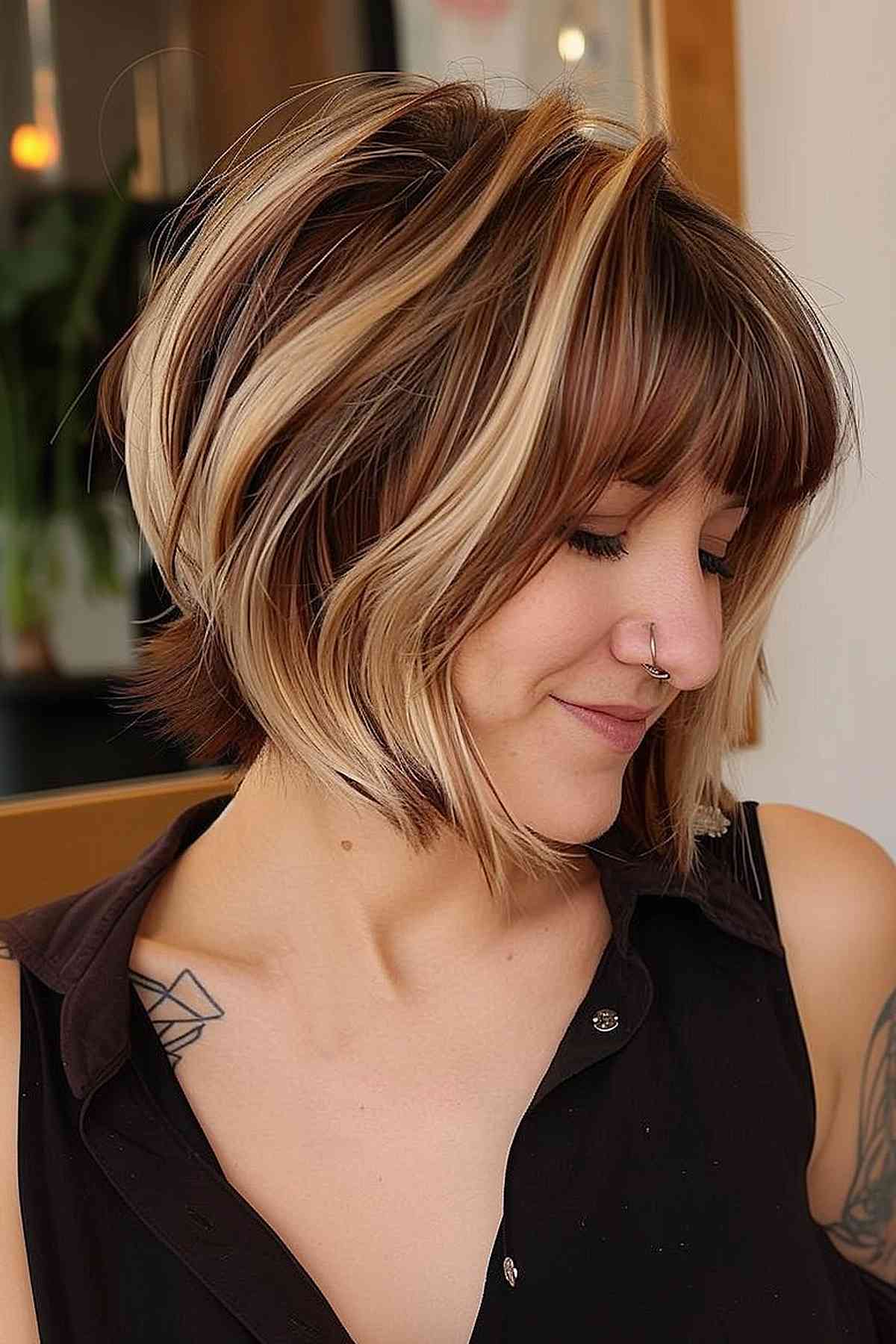 Coupe courte brune avec des mèches blondes et une frange large
