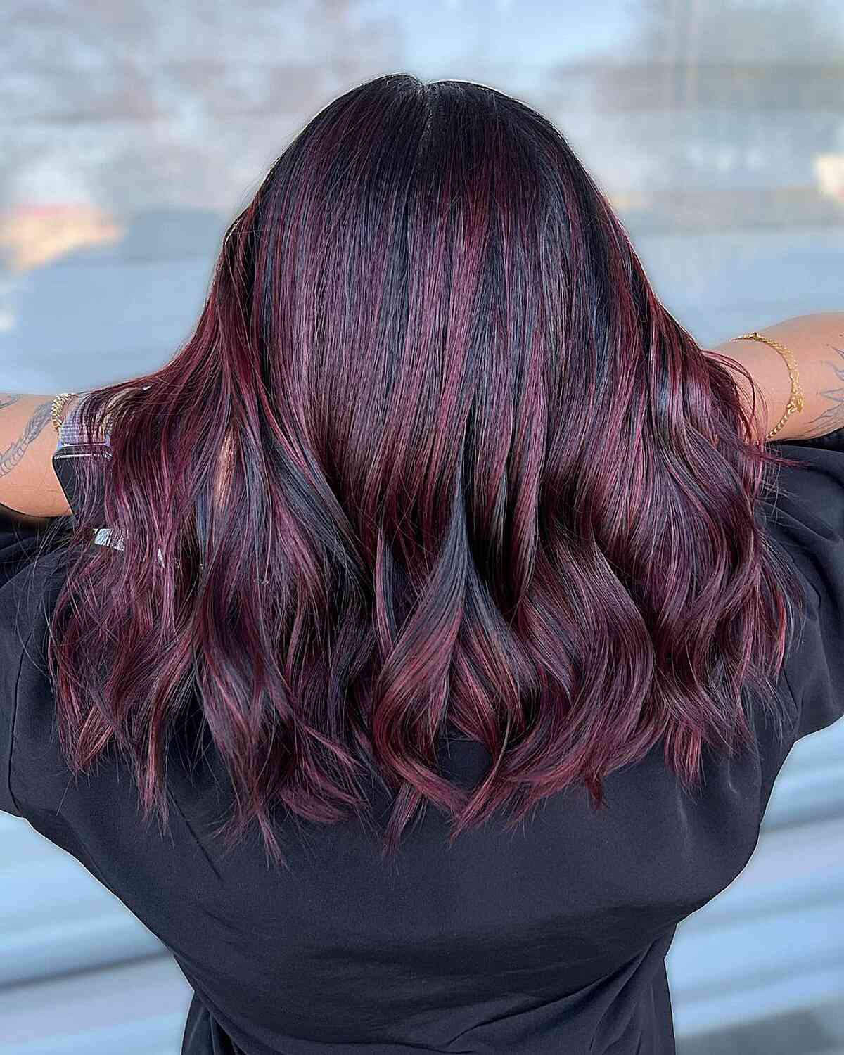 Balayage bordeaux sur cheveux noirs mi-longs