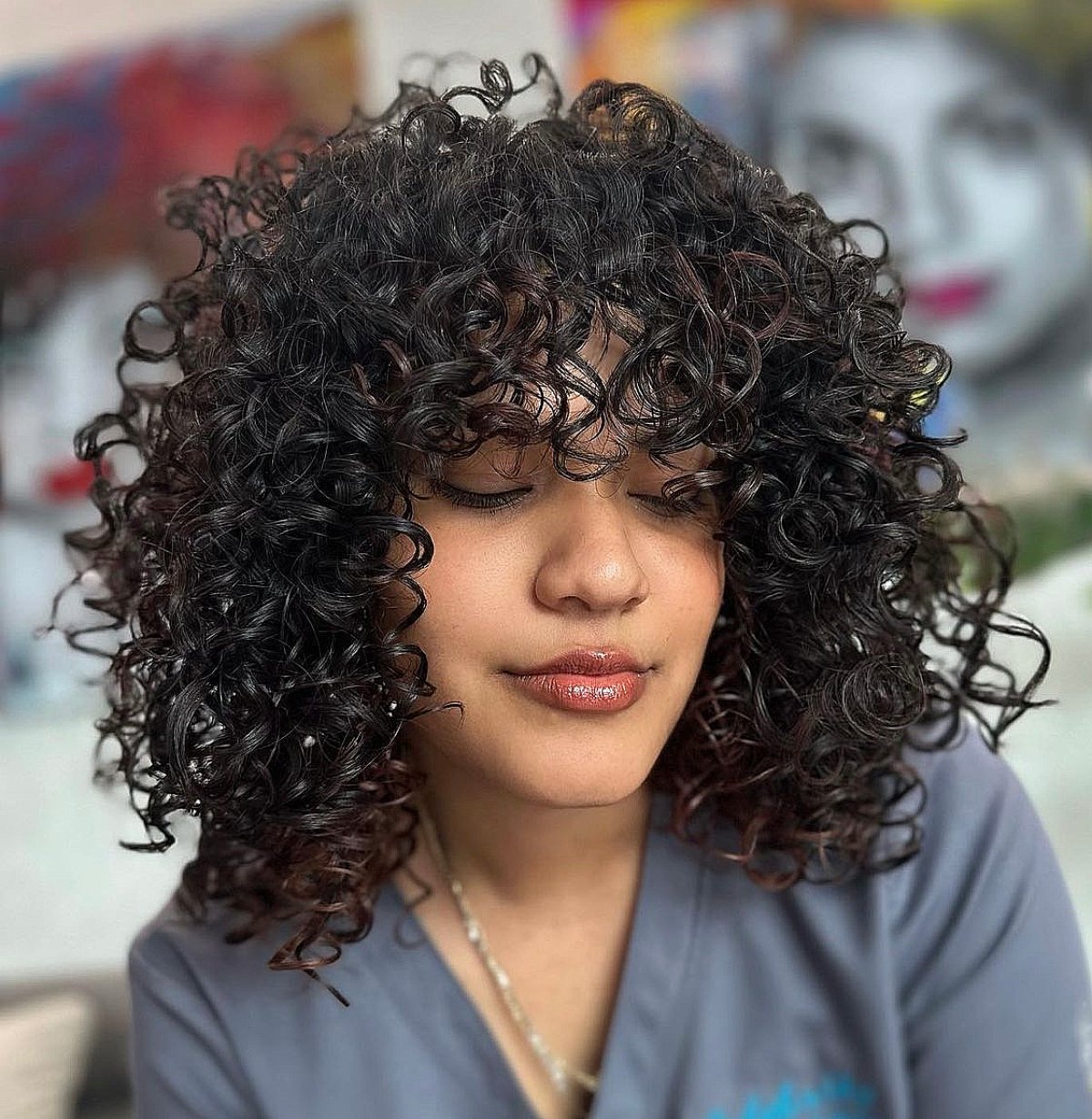 Coupe Cadō brune et bouclée avec des boucles denses et un volume naturel.