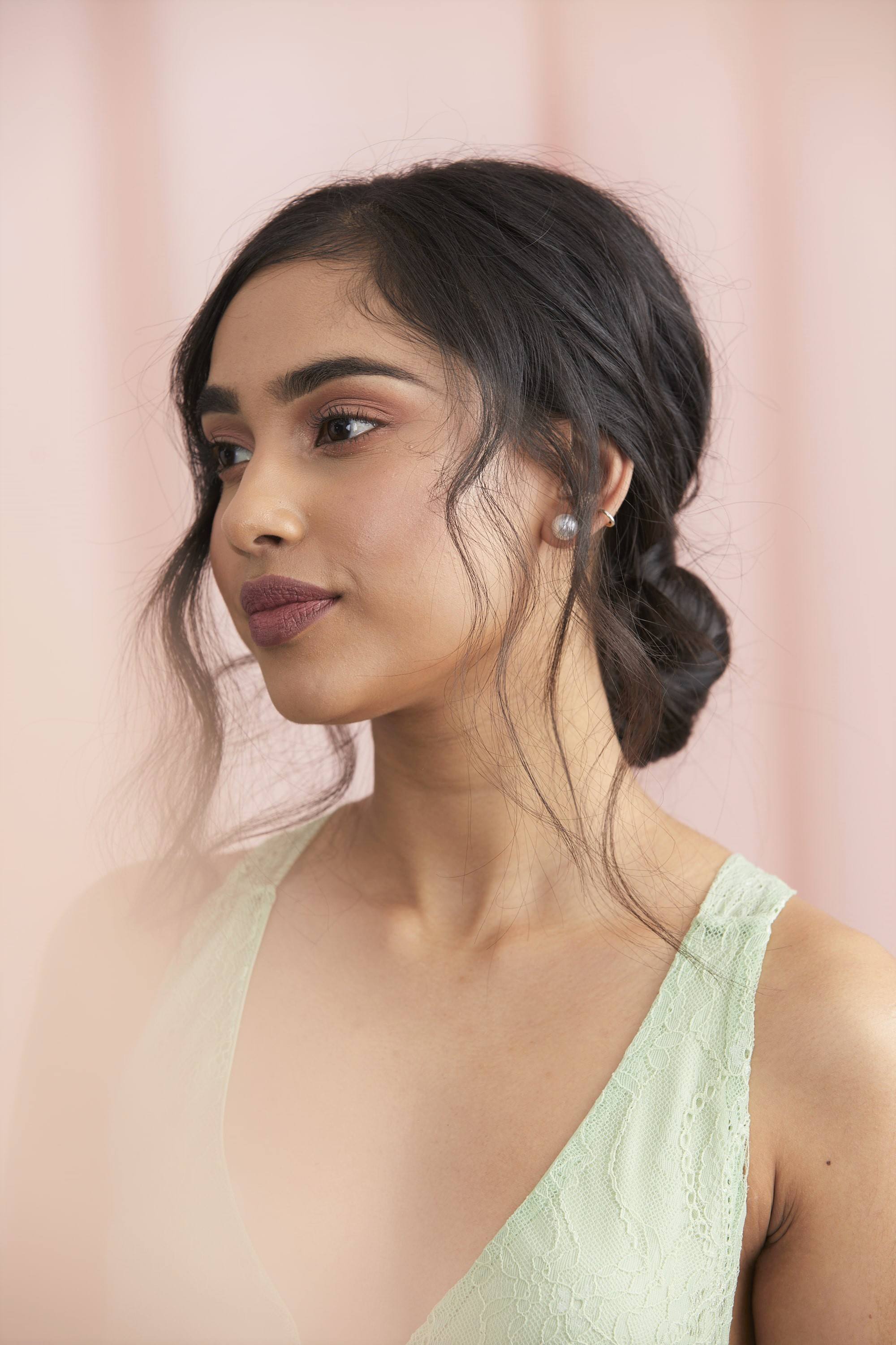 Femme avec des cheveux bruns foncés dans un chignon bas.
