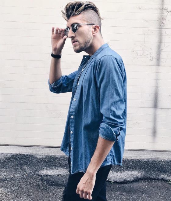Vue de côté d'un modèle masculin avec des cheveux longs balayés en arrière avec une coupe haute.