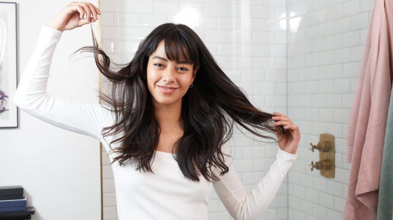 Femme aux cheveux bruns foncés ondulés avec une frange